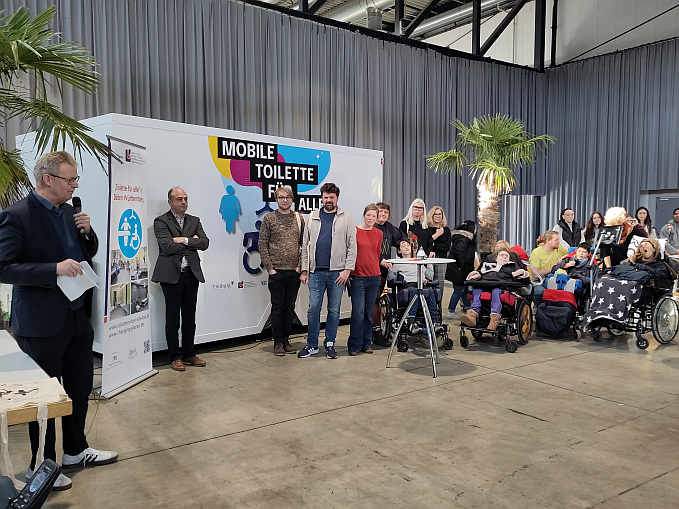 Freiburgs Sozialbürgermeister Ulrich von Kirchbach stellt den Gästen das Projekt „mobile Toilette für alle“  vor.