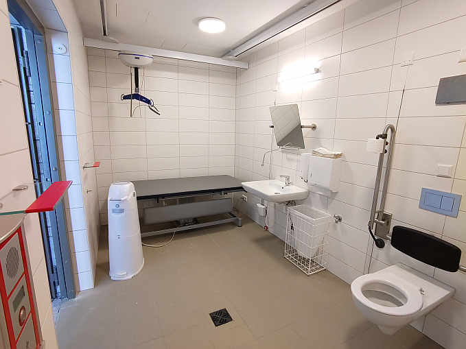 Die „Toilette für alle“  ist zusätzlich ausgestattet mit einer höhenverstellbaren Pflegeliege, Deckenlifter und luftdichtem Windeleimer. Sie ist mit dem Euro-Schlüssel jederzeit zugänglich.